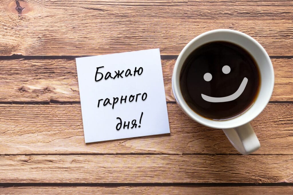Побажання гарного дня з кавою та усмішкою на дерев’яному столі